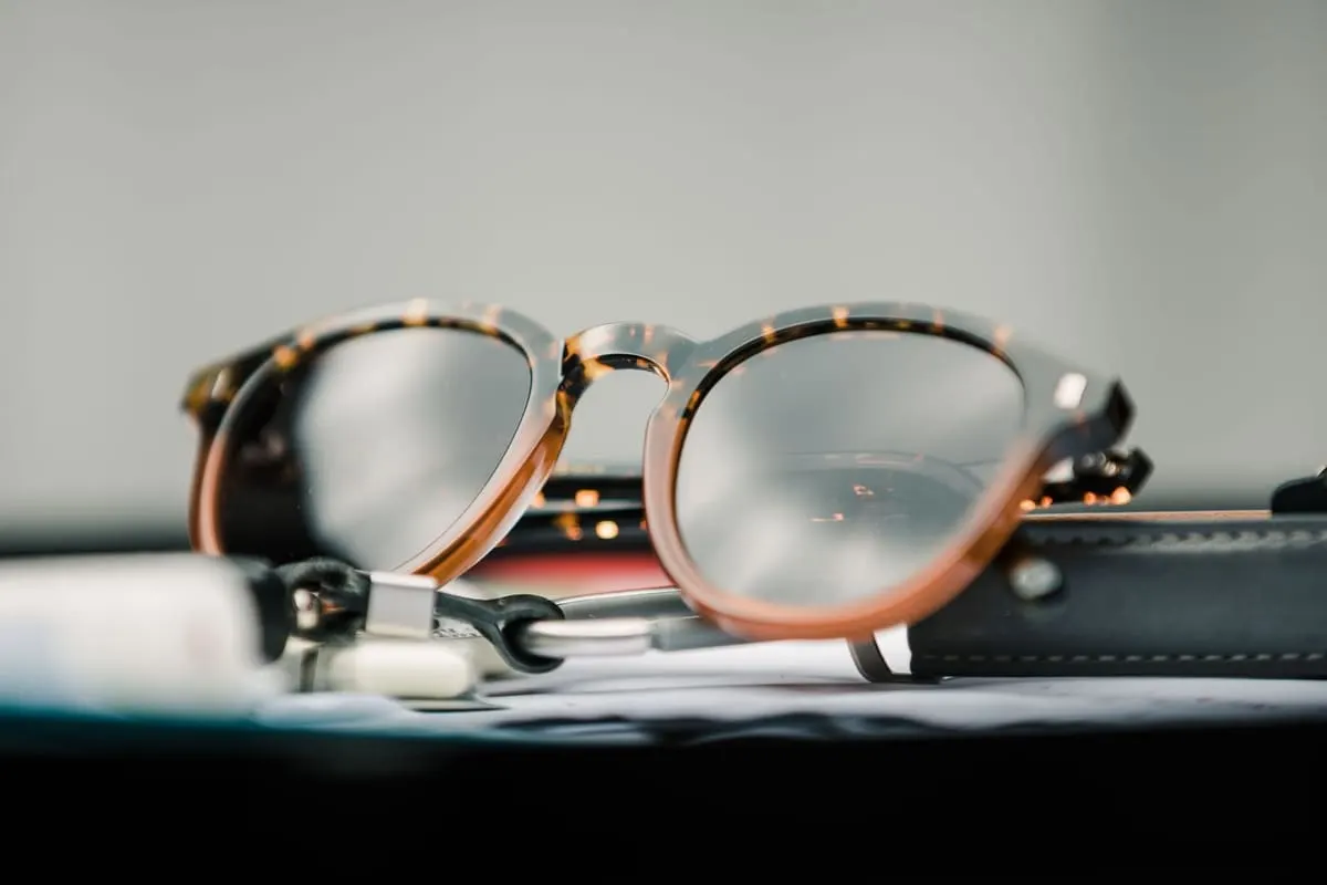 Rond montuur met donkere glazen op een leren etui